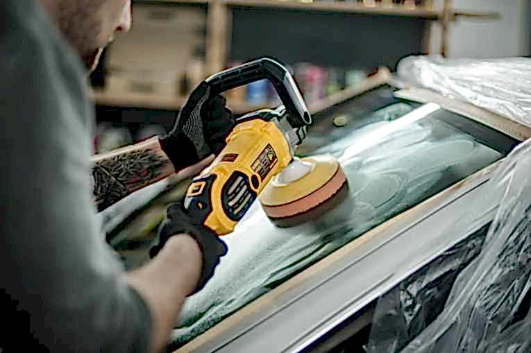 На фото крупным планом полировальная машина DWP849X фирмы DeWalt. Мастер выполняет полировку с использование абразивной пасты Krytex Mega Optic.