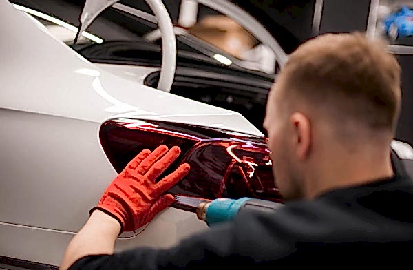 На фото мастер-технолог «AR-Detailing» за работой. Производится поклейка тонировочной антигравийной пленки на задний фонарь автомобиля.