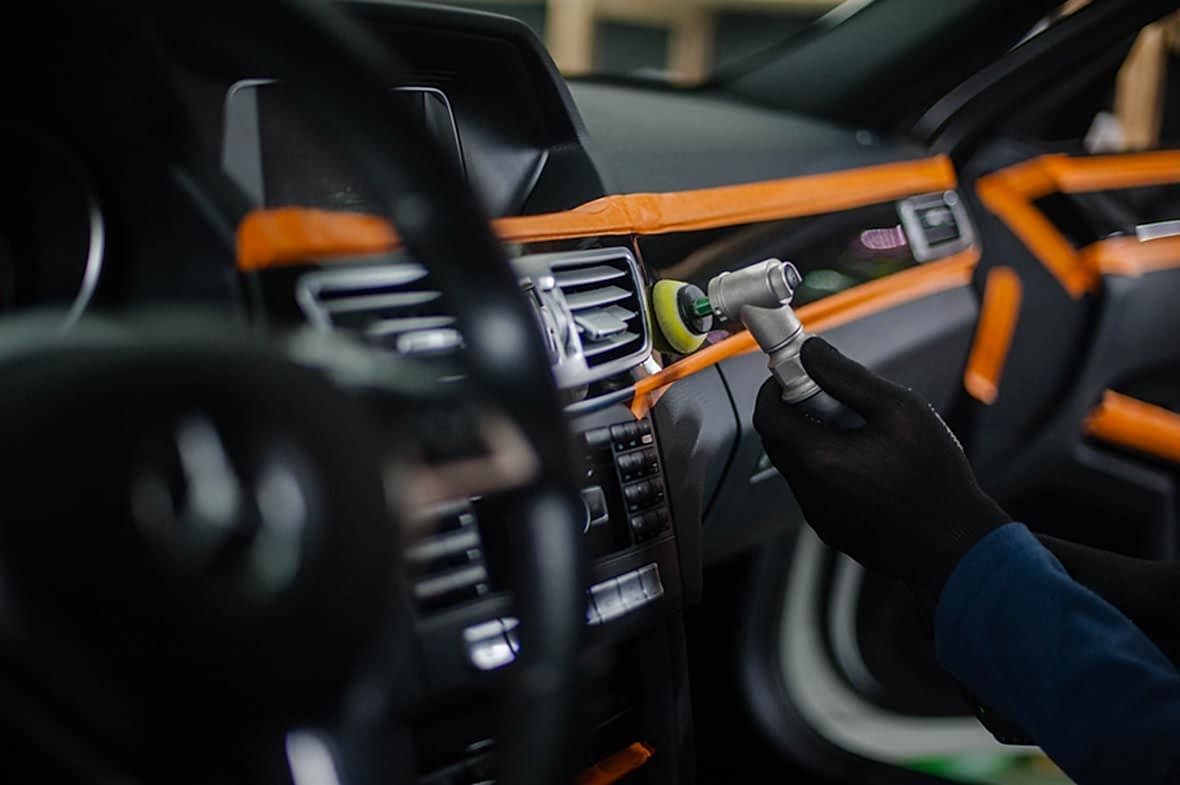 На фото мастер фирмы «AR-Detailing» выполняет машинную полировку деревянного декора в салоне автомобиля.